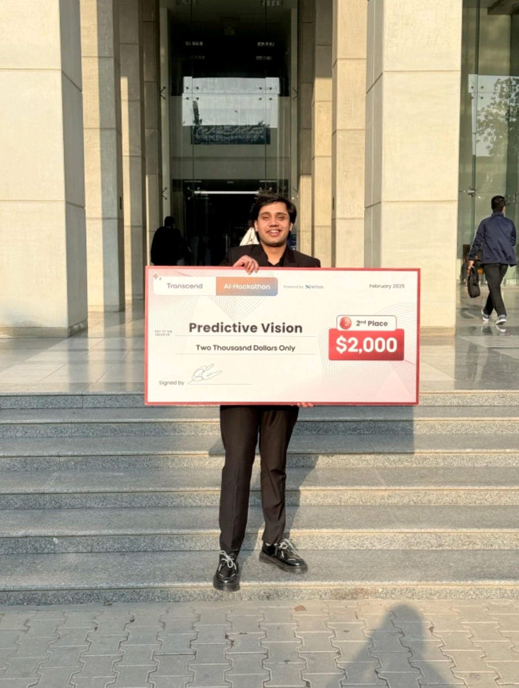 Usmar holding the $2,000 second-place check at the Transcend AI Hackathon
